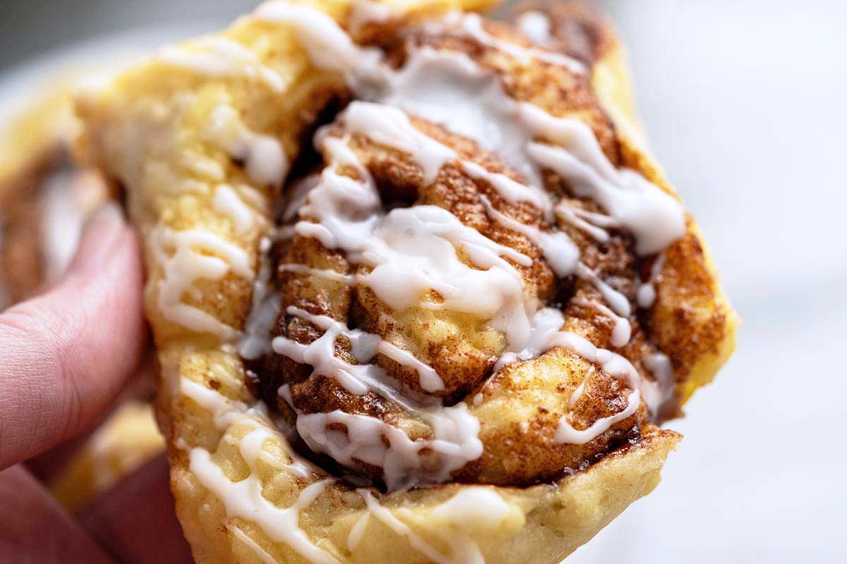 close up of hand holding healthier low cal high protein cinnamon roll