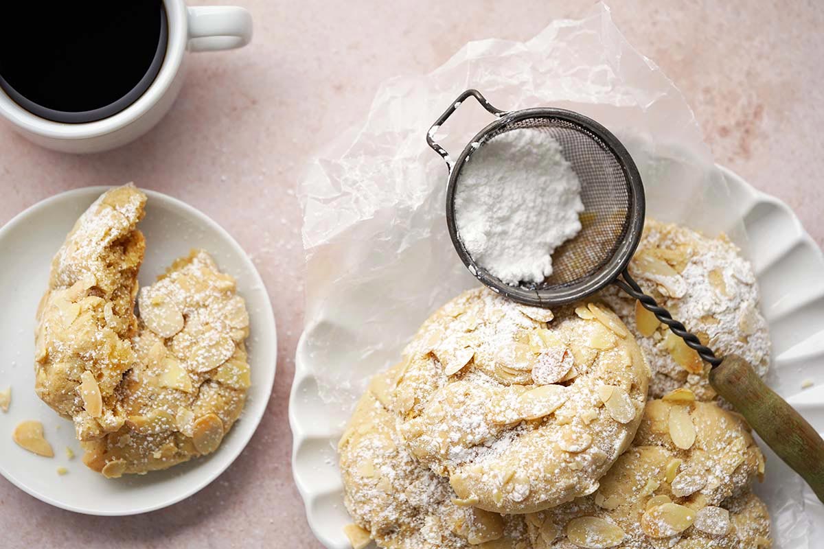 plate of almond croissant cookies with cup of coffee