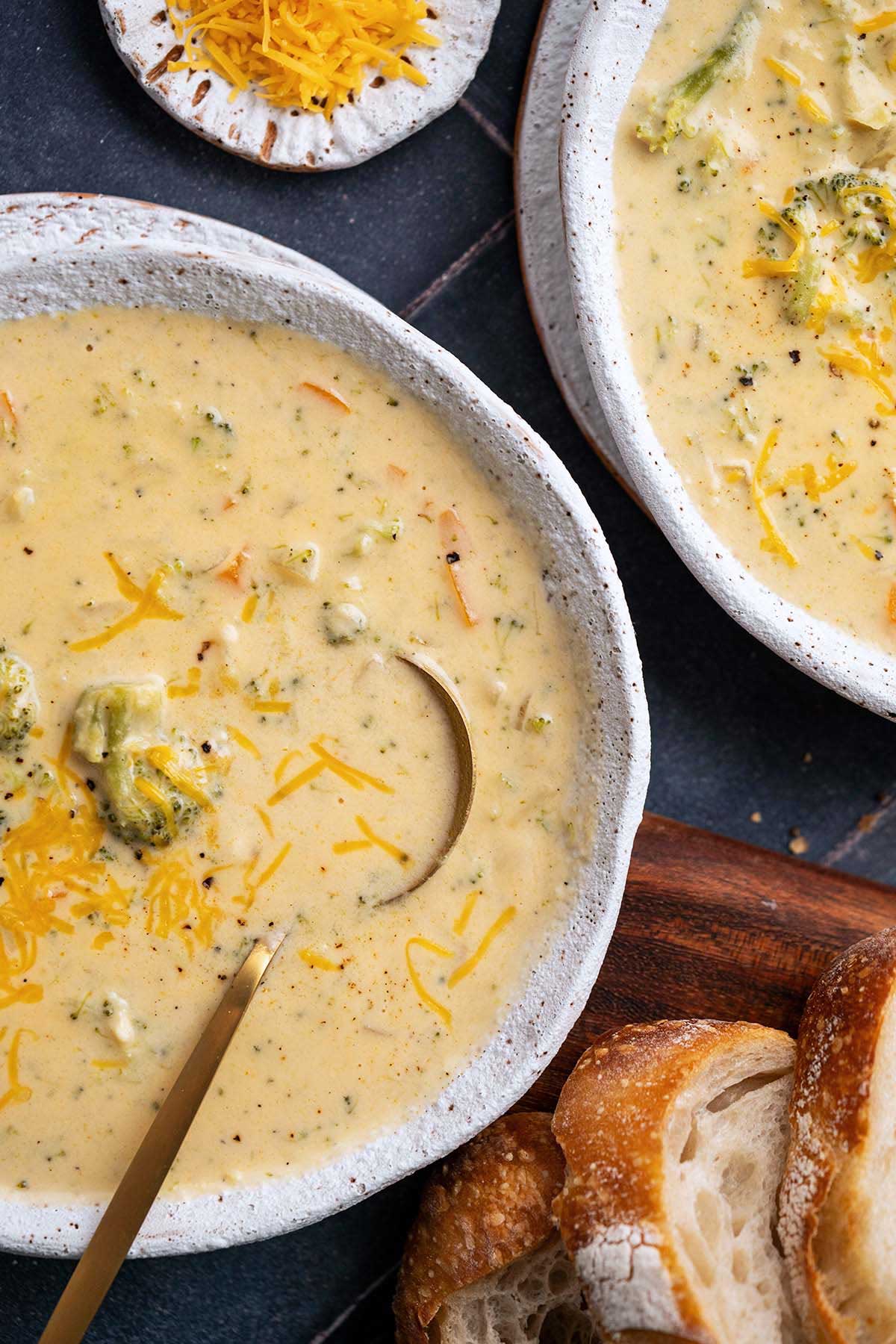 top view of bowls of easy cream of broccoli cheese soup with chicken for extra protein