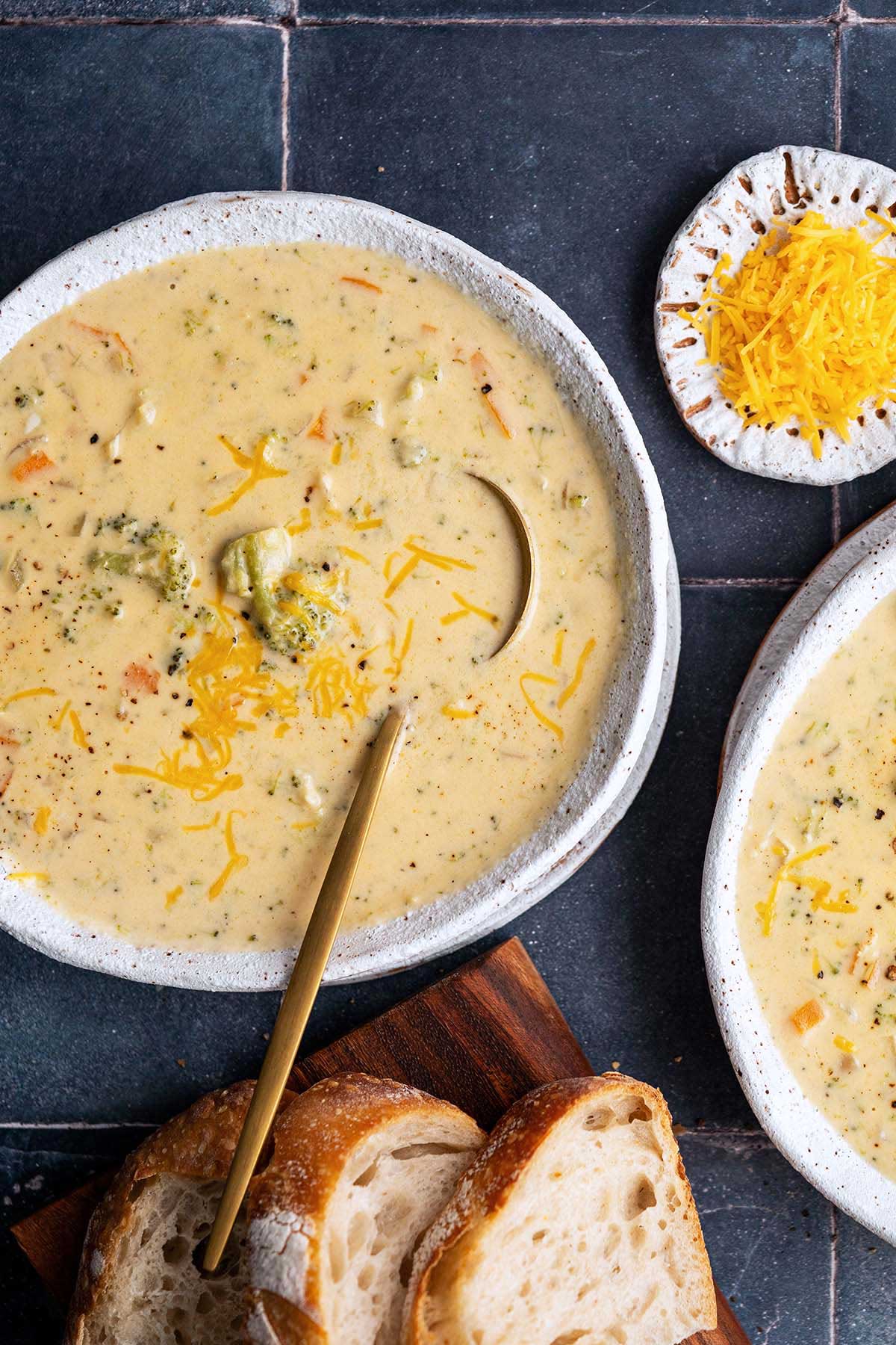 top view of white stoneware bowls with broccoli cheddar cheese soup