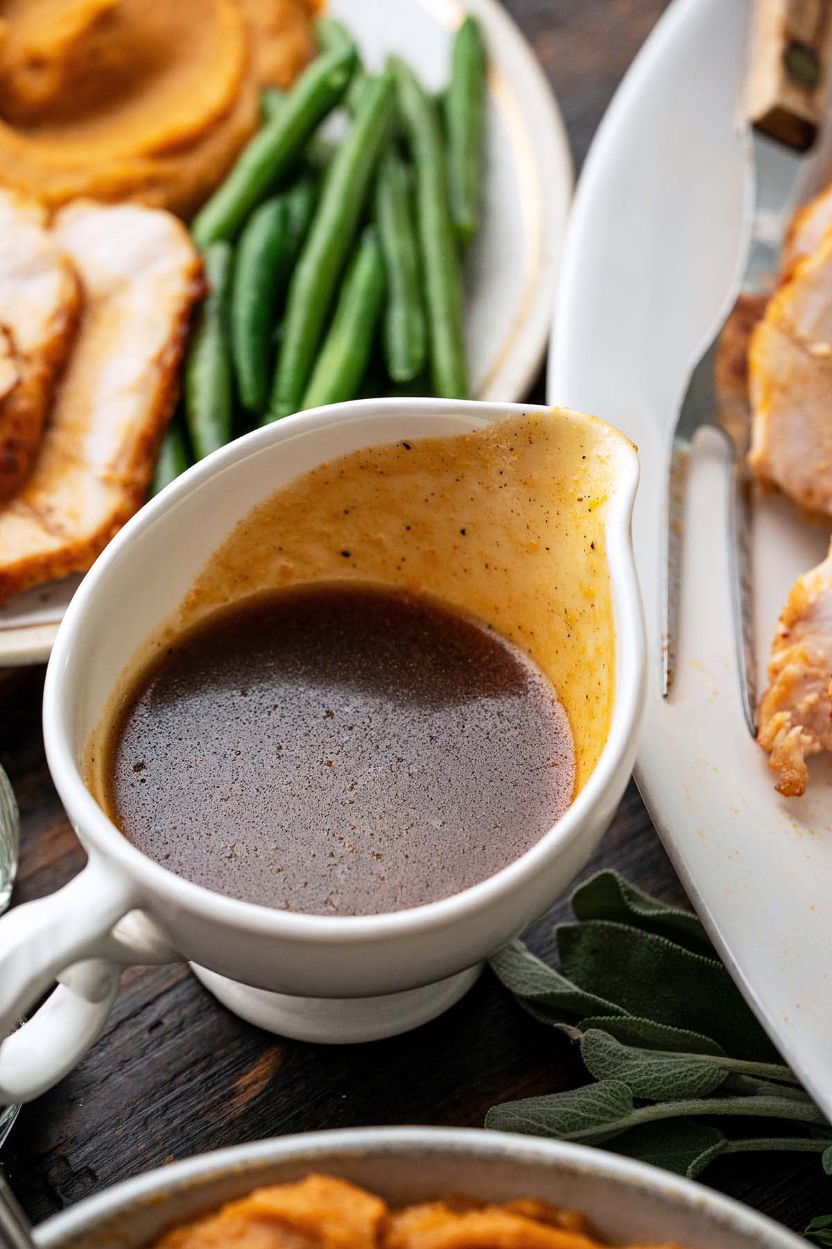 maple bourbon glaze in gravy boat on thanksgiving dinner table