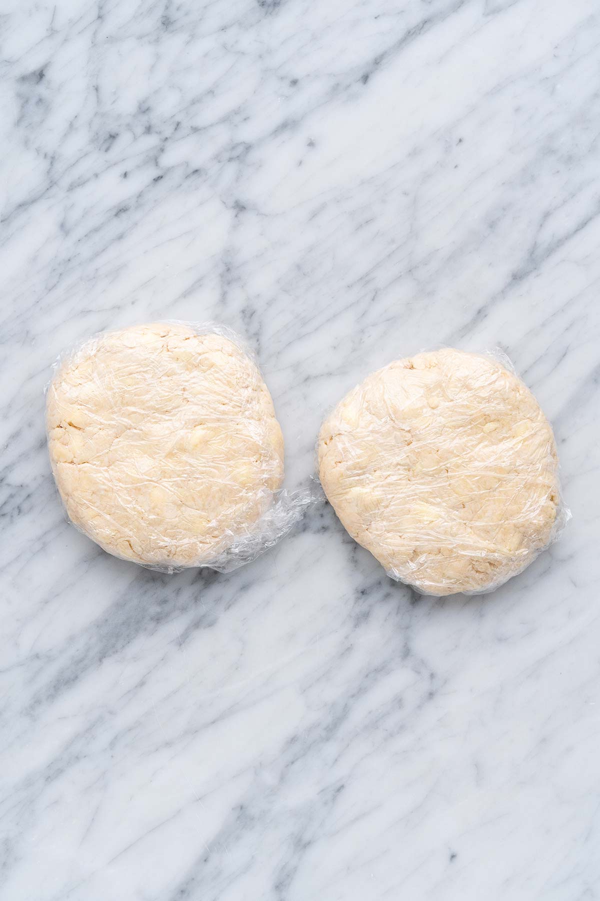 2 disks of dough wrapped in plastic wrap