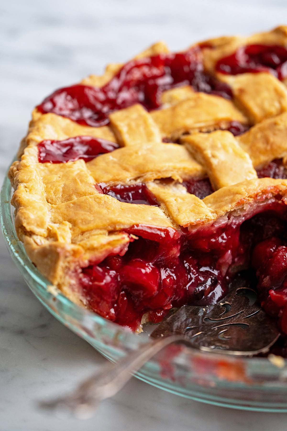 close up view of side of homemade tart cherry pie showing juicy filling