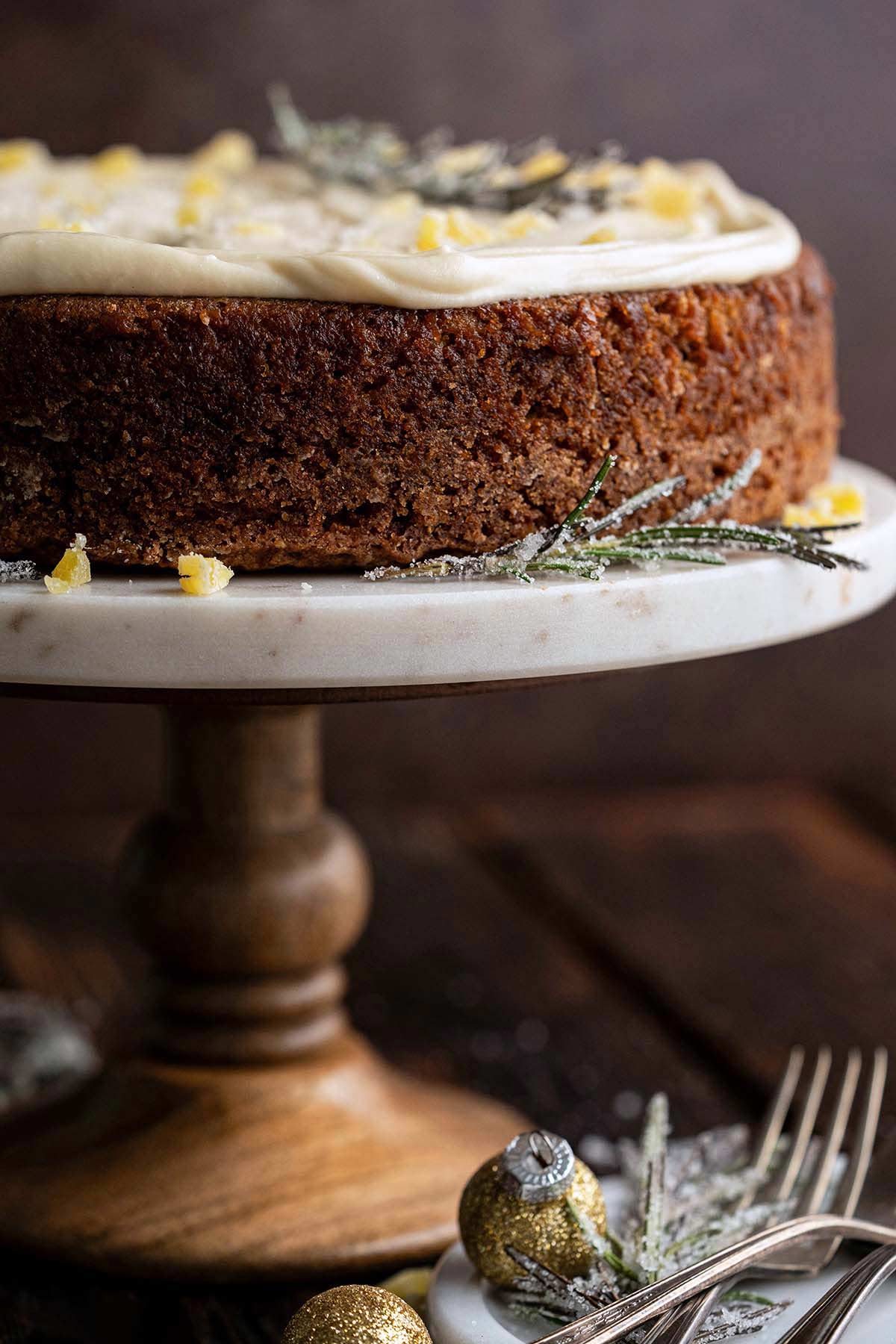 front view of gingerbread apple spice cake with molasses on wood and marble cake stand