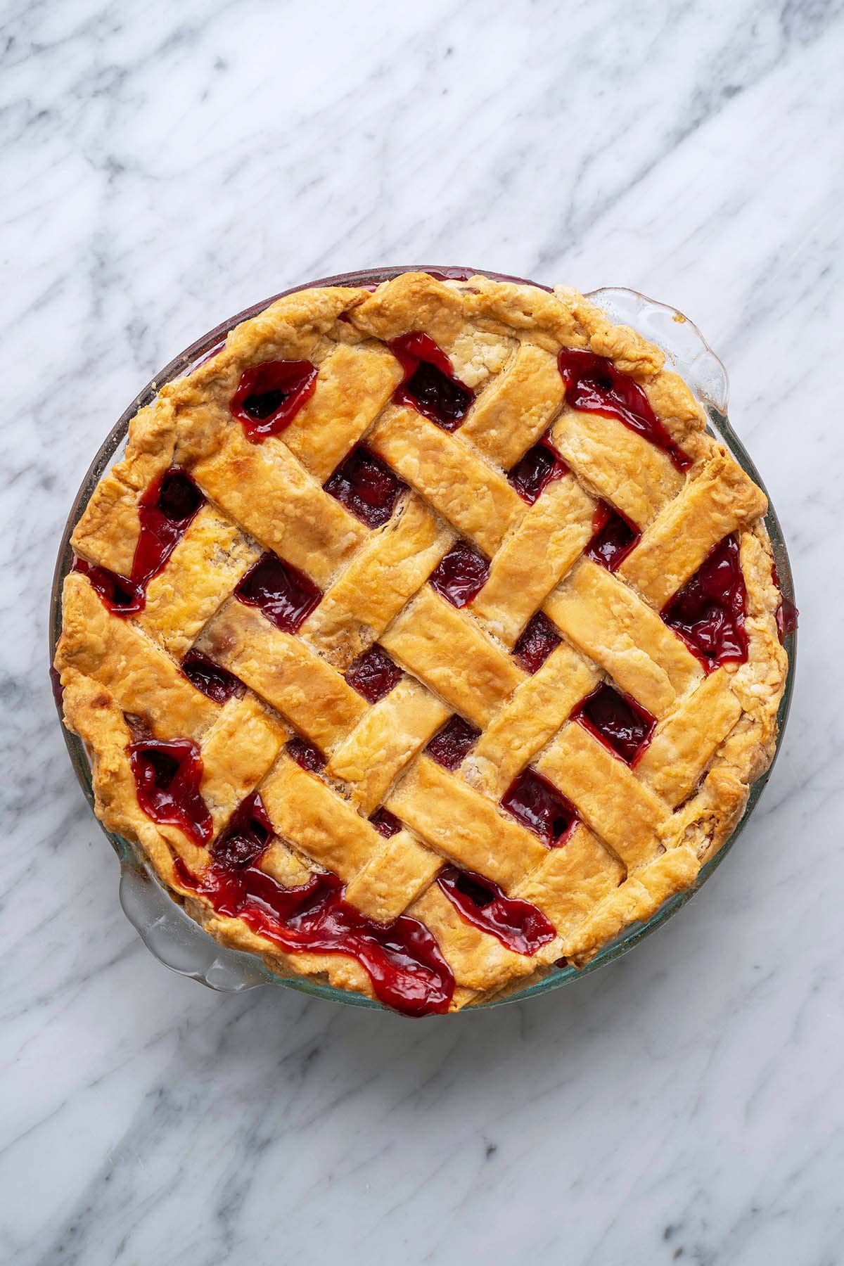 homemade cherry pie on marble countertop