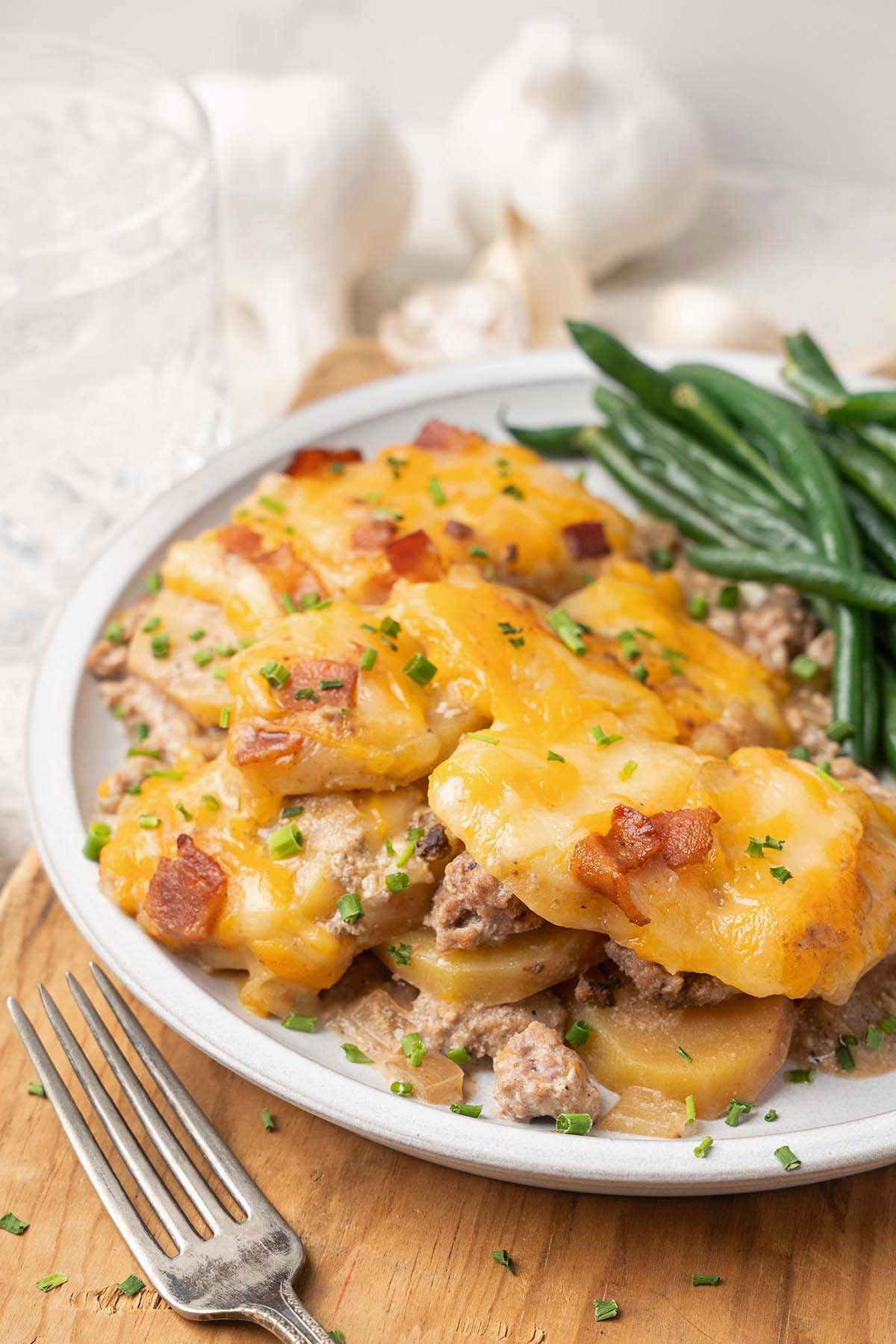 close up front view of serving of ground meat and potato casserole topped with cheese