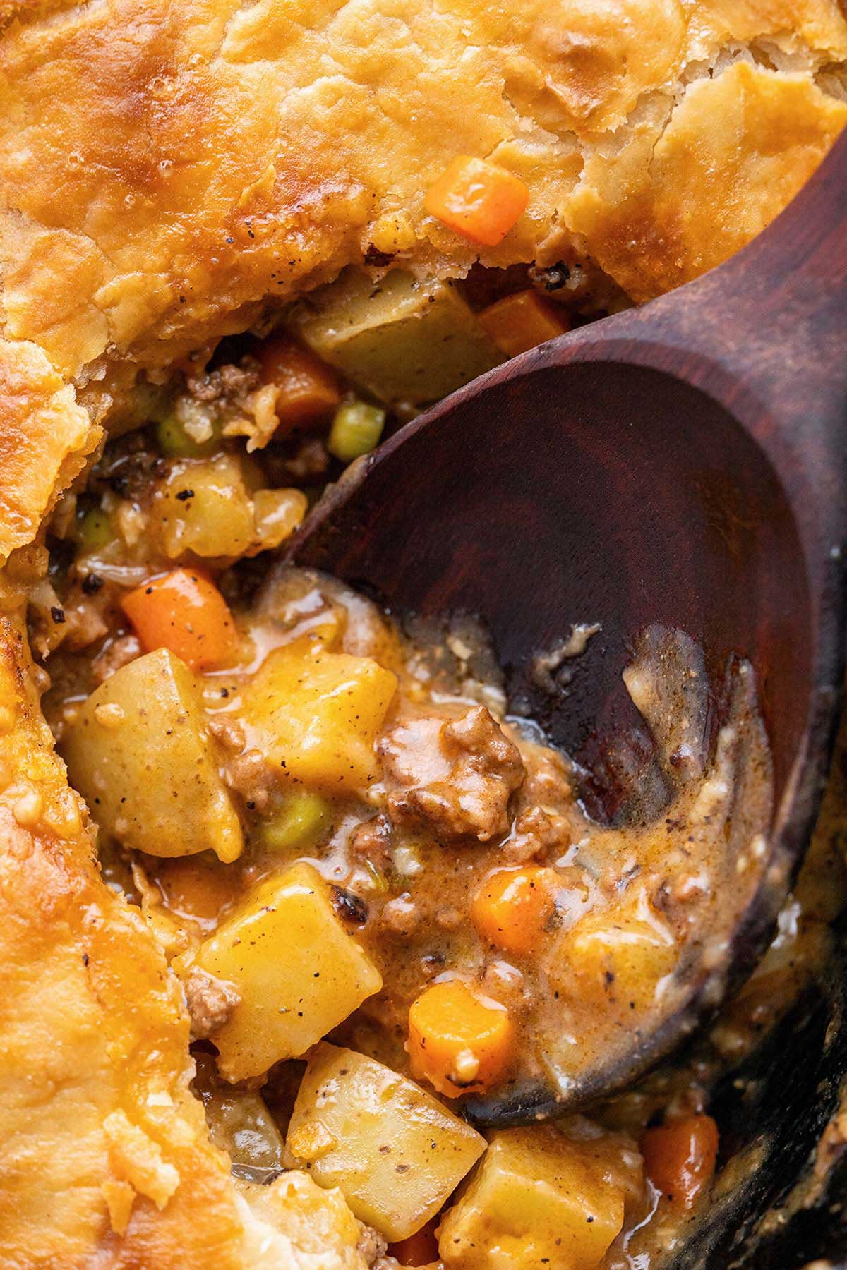 close up top view of skillet ground beef pot pie showing rich brown gravy