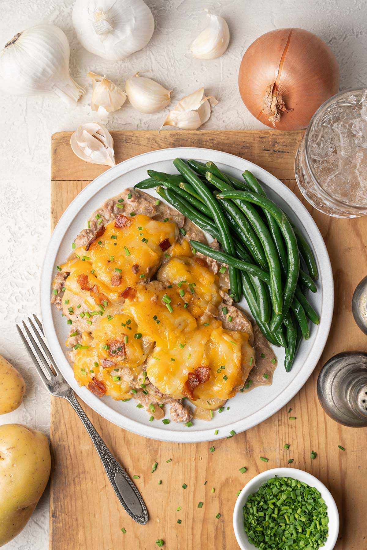 ground beef casserole with potatoes and cheese plated with green beans