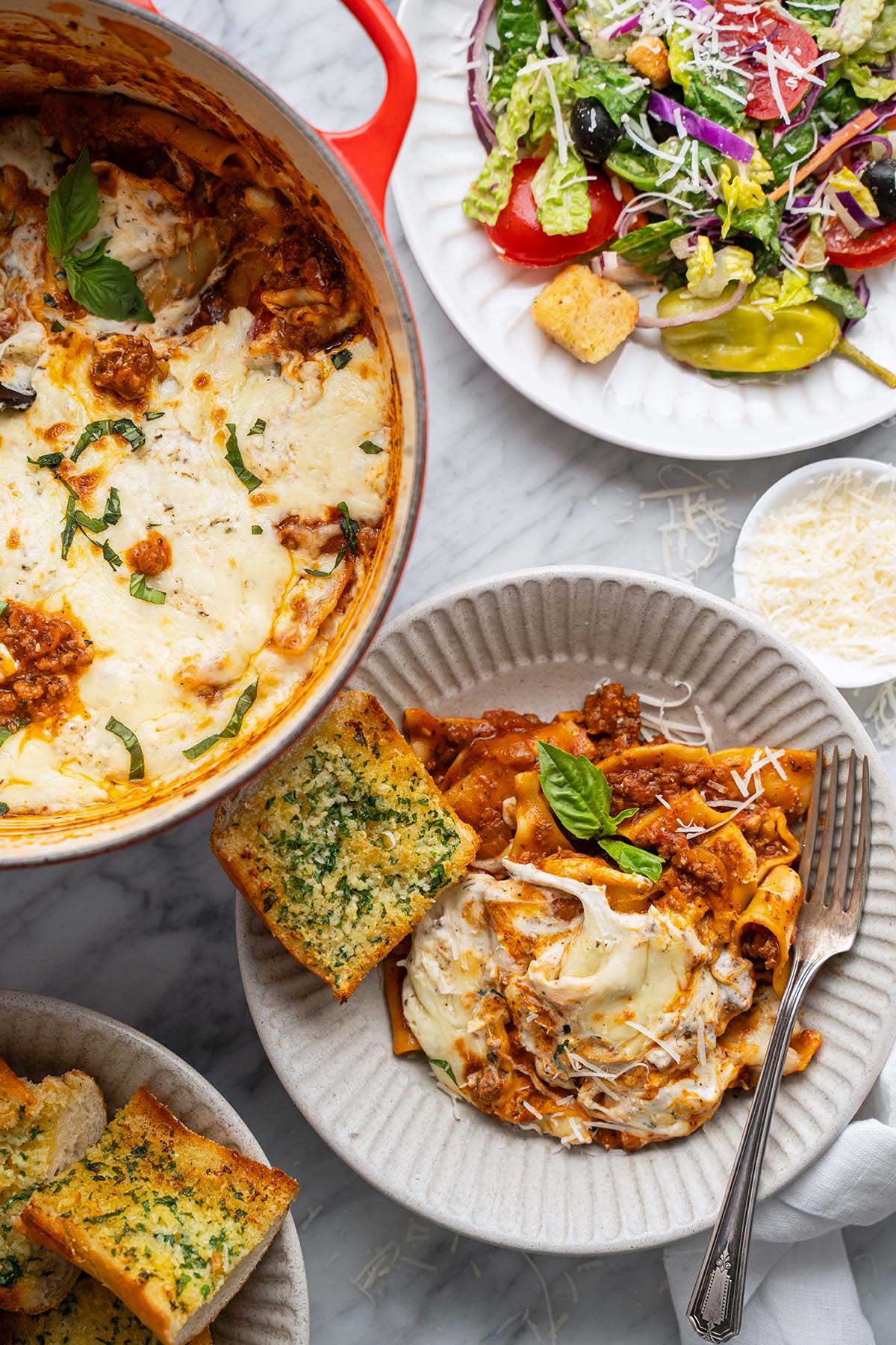 one pan beef lasagna served with garlic bread and Italian salad