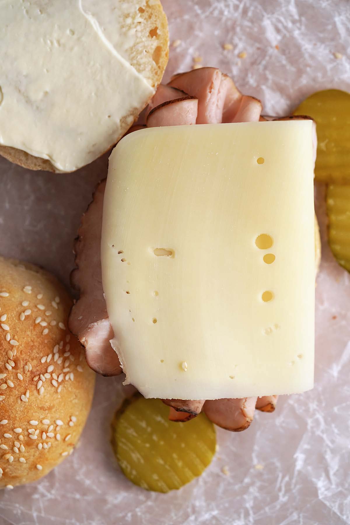top view of assembling turkey and cheese sandwich on sourdough bun