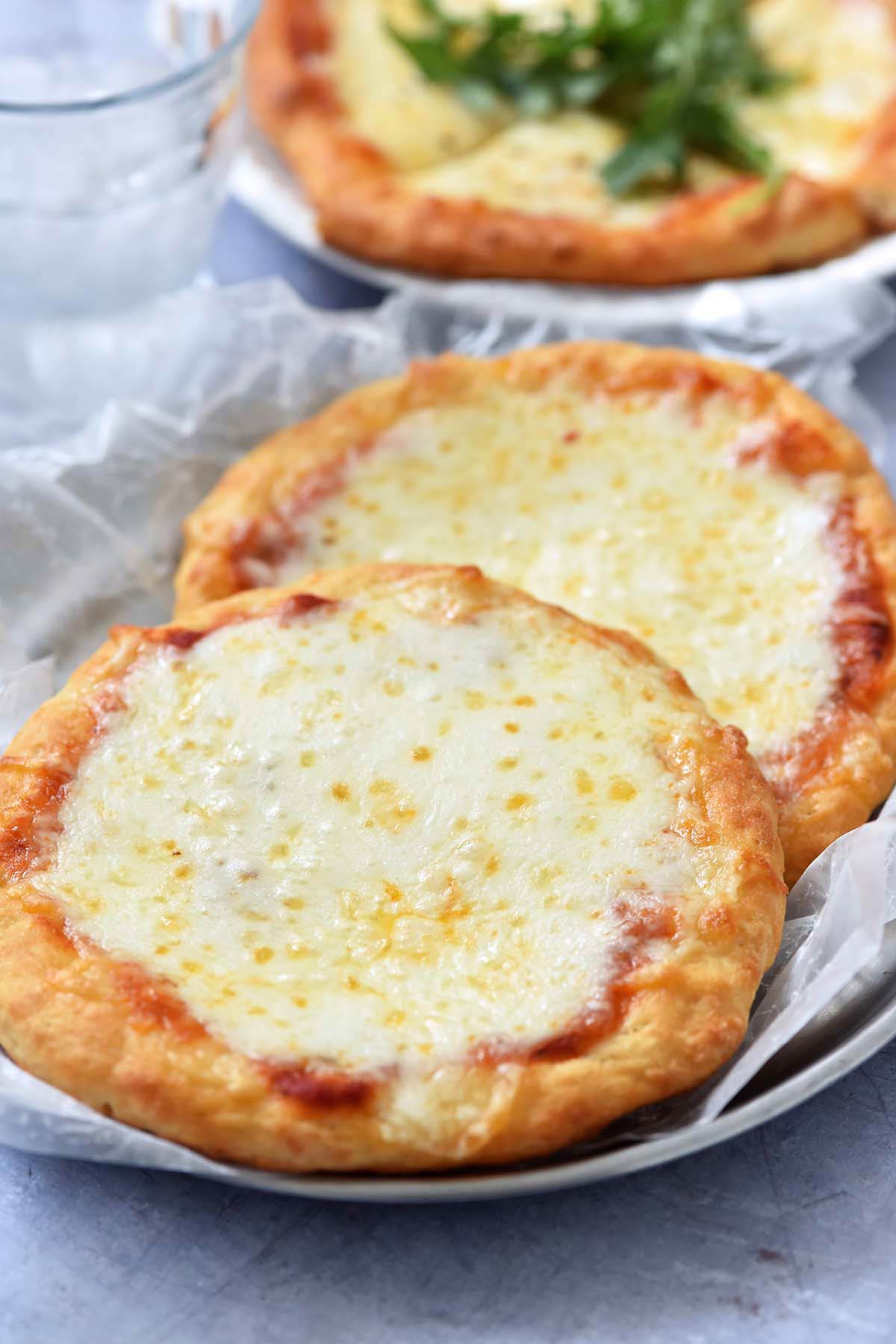 front view of greek yogurt pizzas topped with sauce and cheese on tray