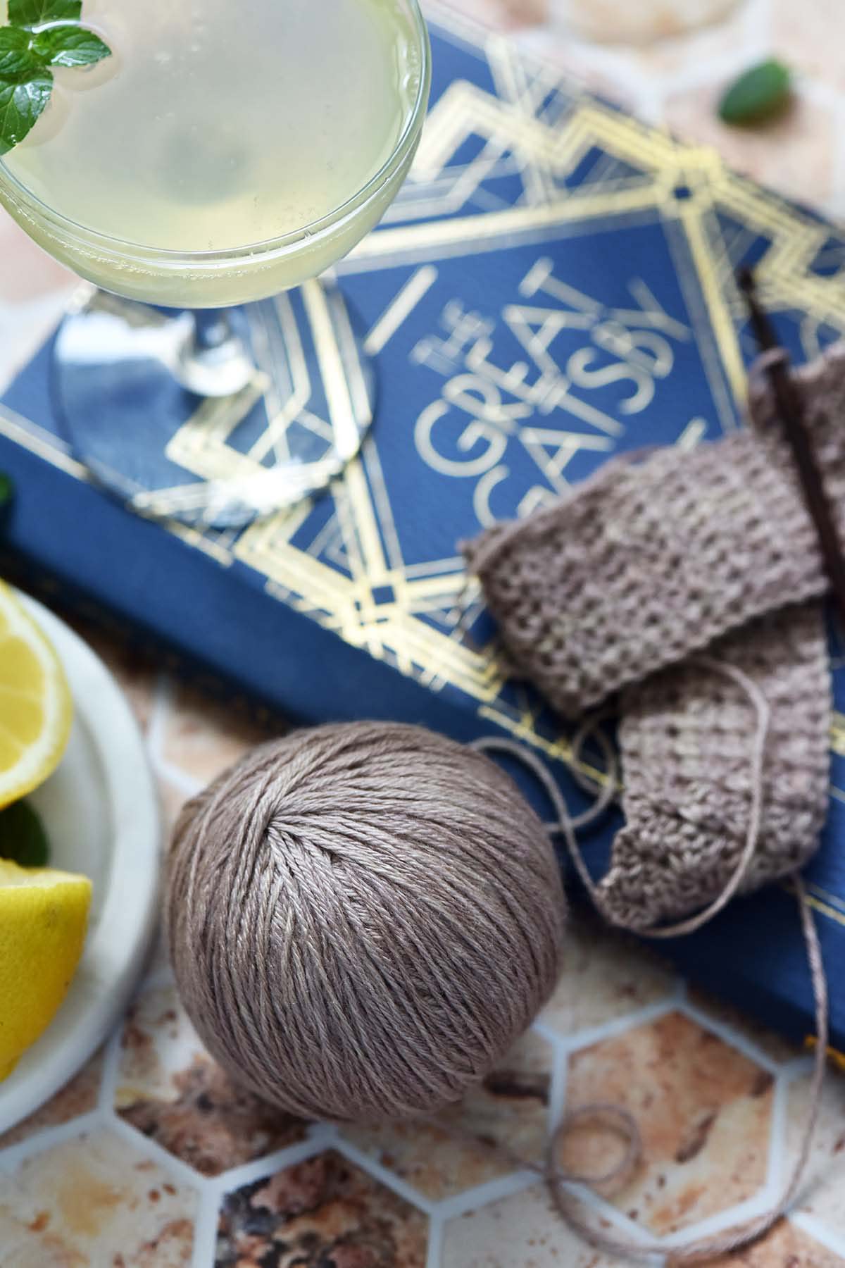 mauvy rose gold yarn with sparkling drink and the great gatsby book
