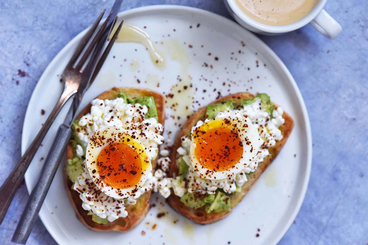top view of runny soft boiled eggs on toast with latte