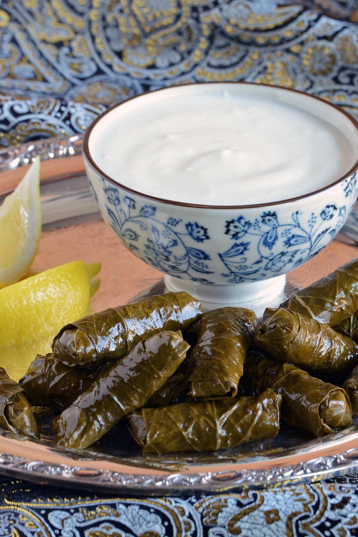 vegetarian stuffed grape leaves served with yogurt and lemon