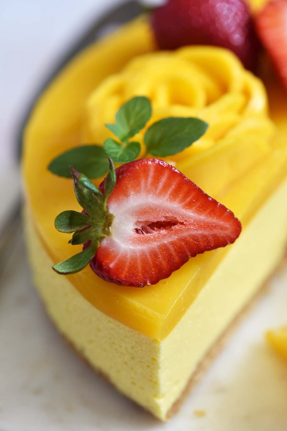 fluffy no bake cheesecake with mango jelly topping and fresh strawberries