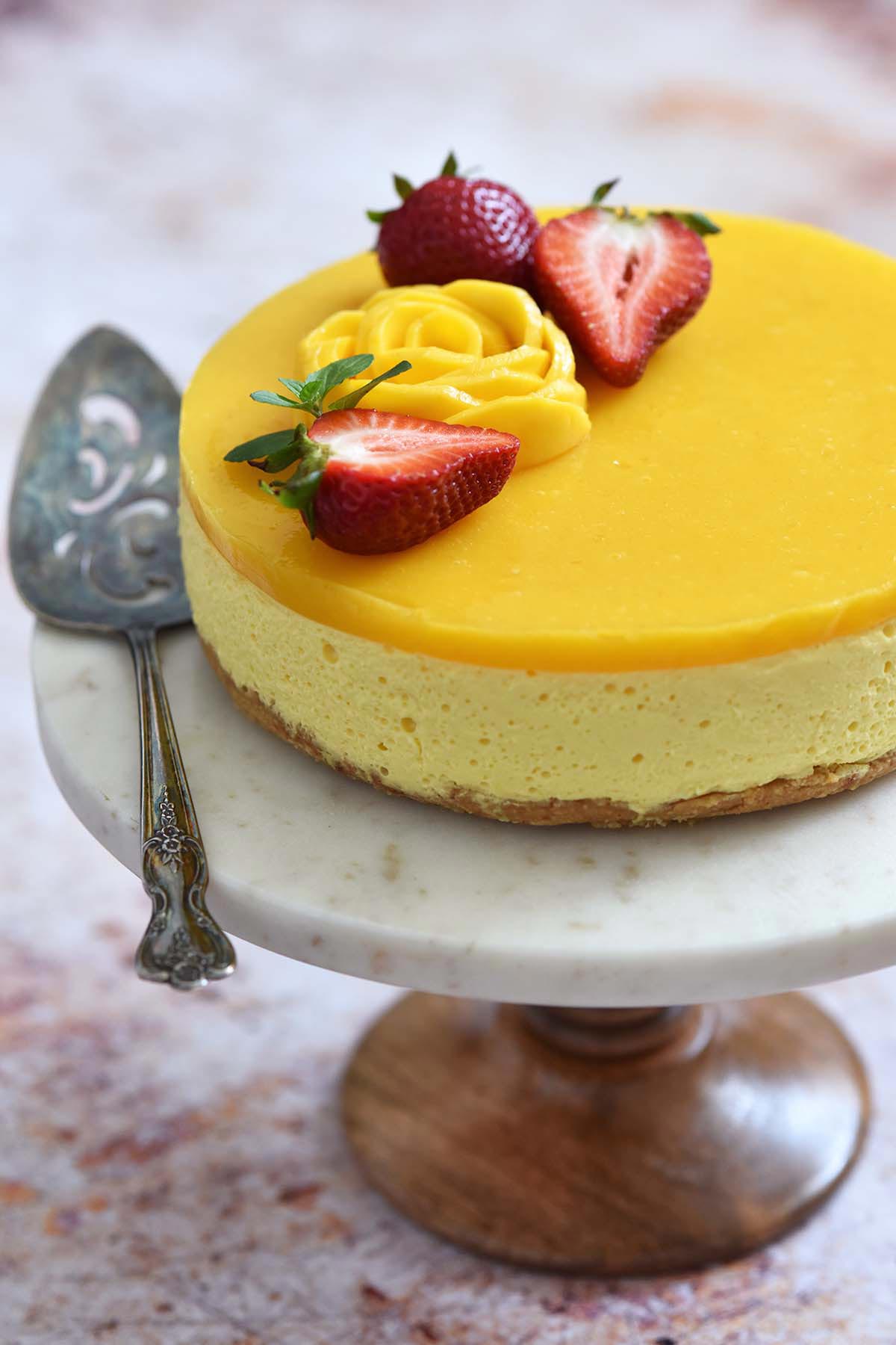 no bake mango cheesecake on wood and marble cake stand