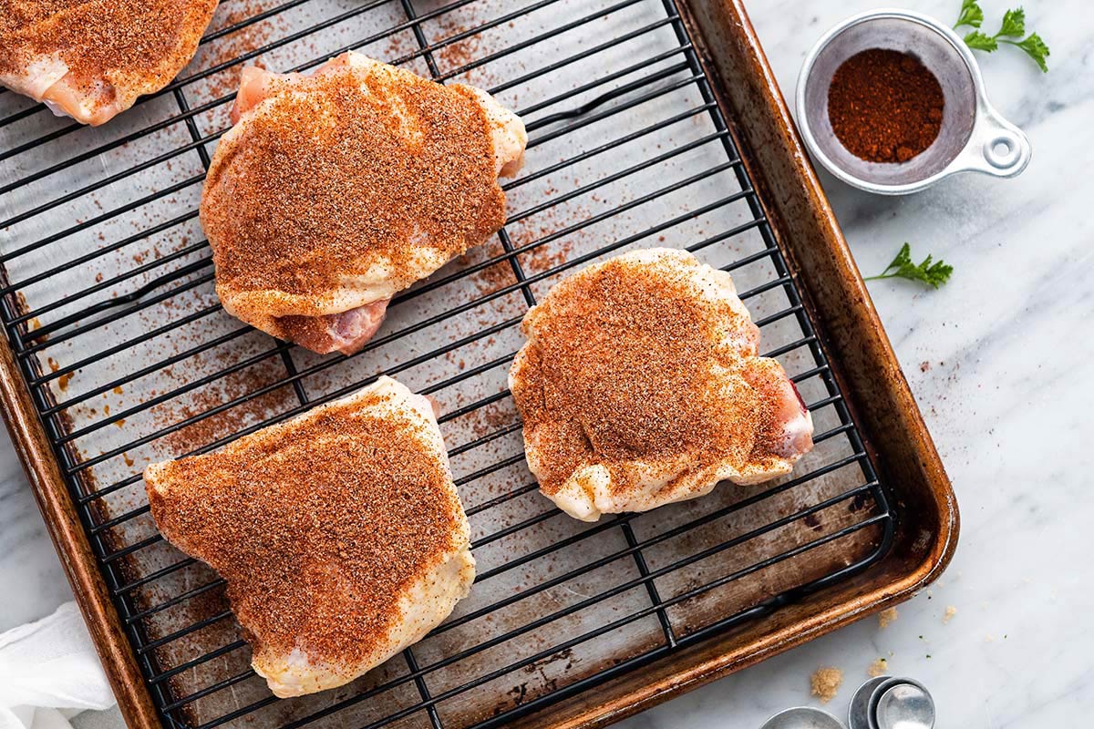dry rub bbq chicken thighs on tray before baking