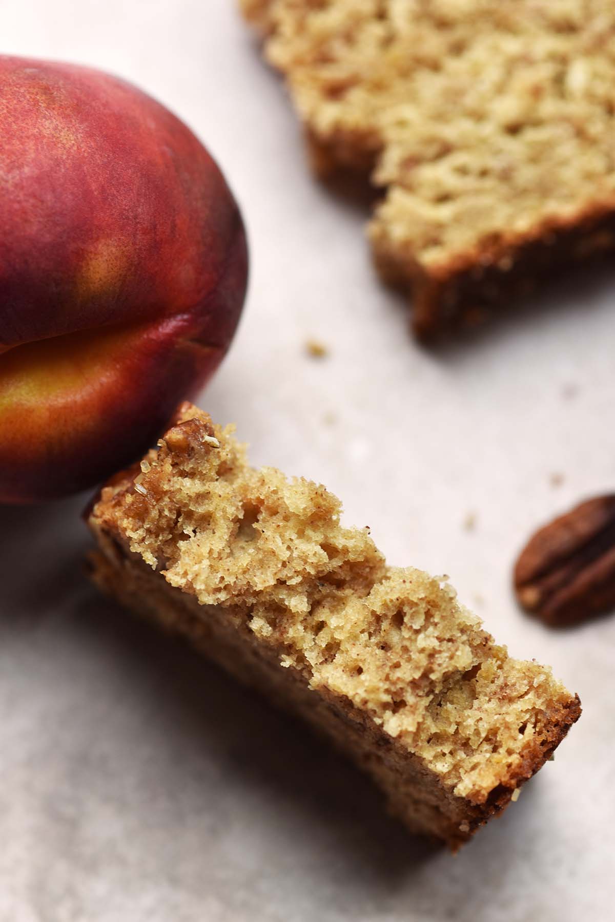 partially eaten slice of sourdough discard peach bread showing moist tender crumb