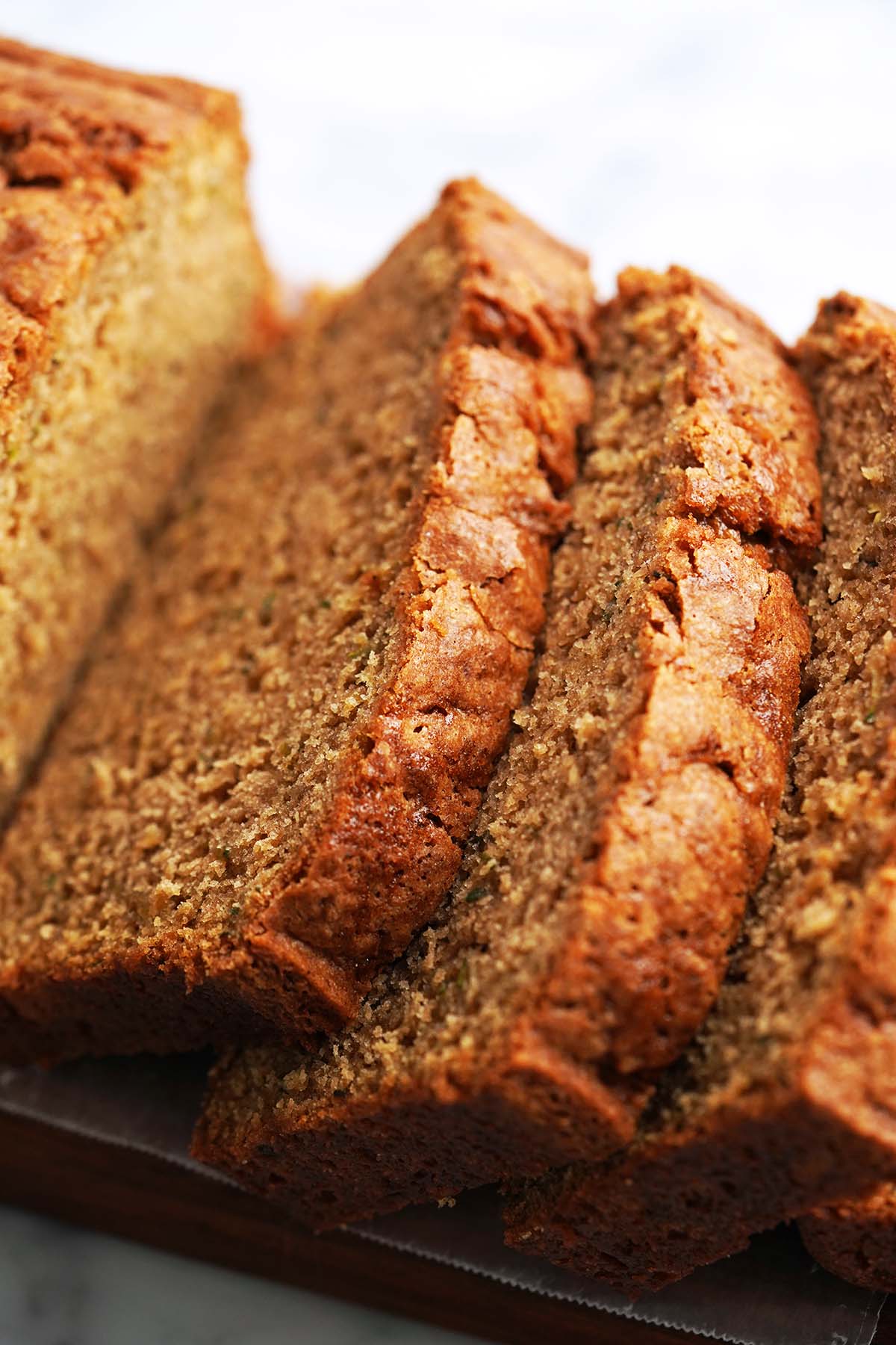 sliced zucchini quick bread with sourdough discard on cutting board