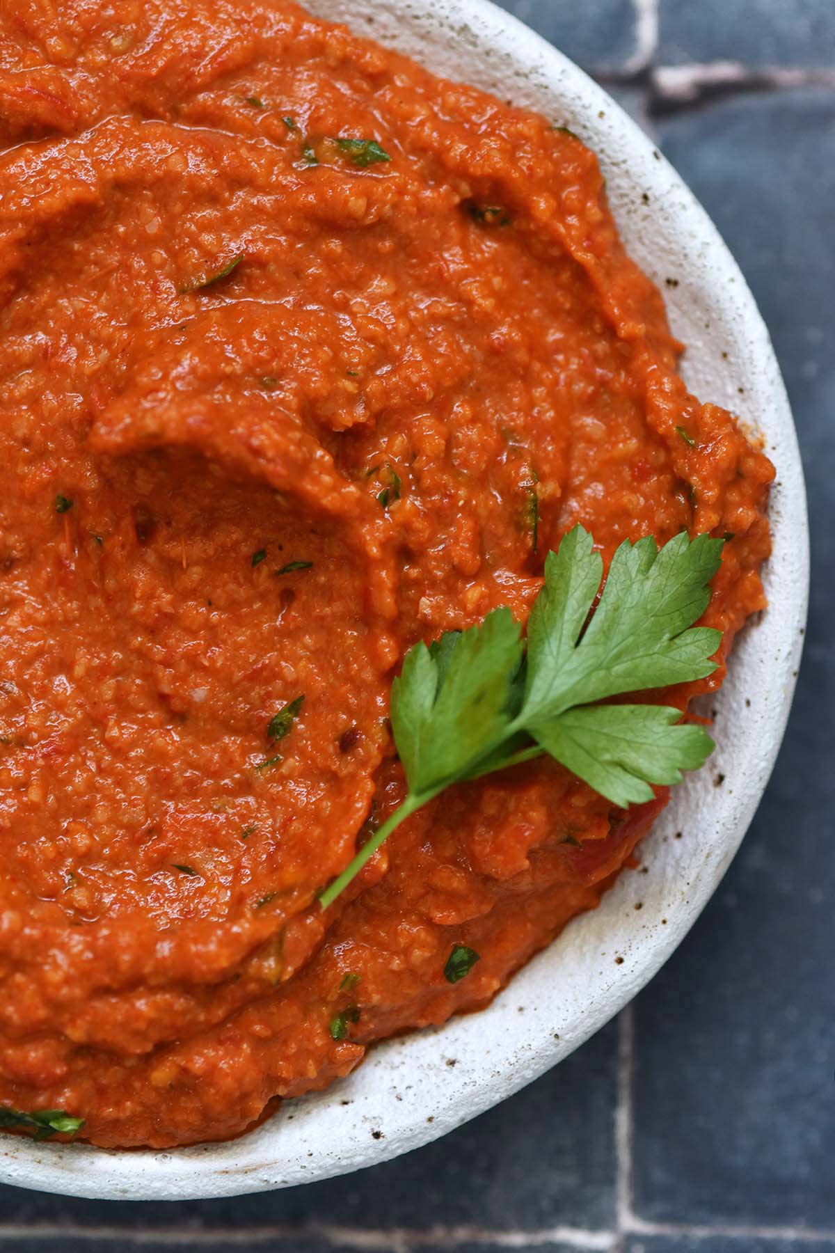 close up top view of salsa romesco in white stoneware bowl