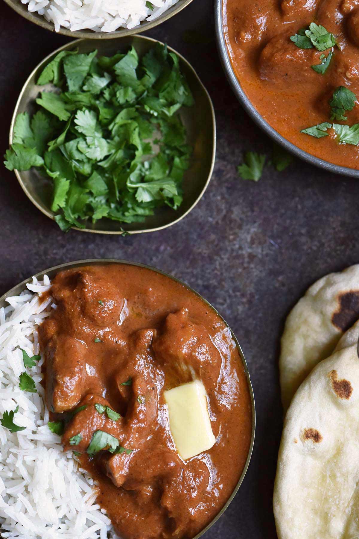 serving of murgh makhani in dish with basmati rice and fresh cilantro