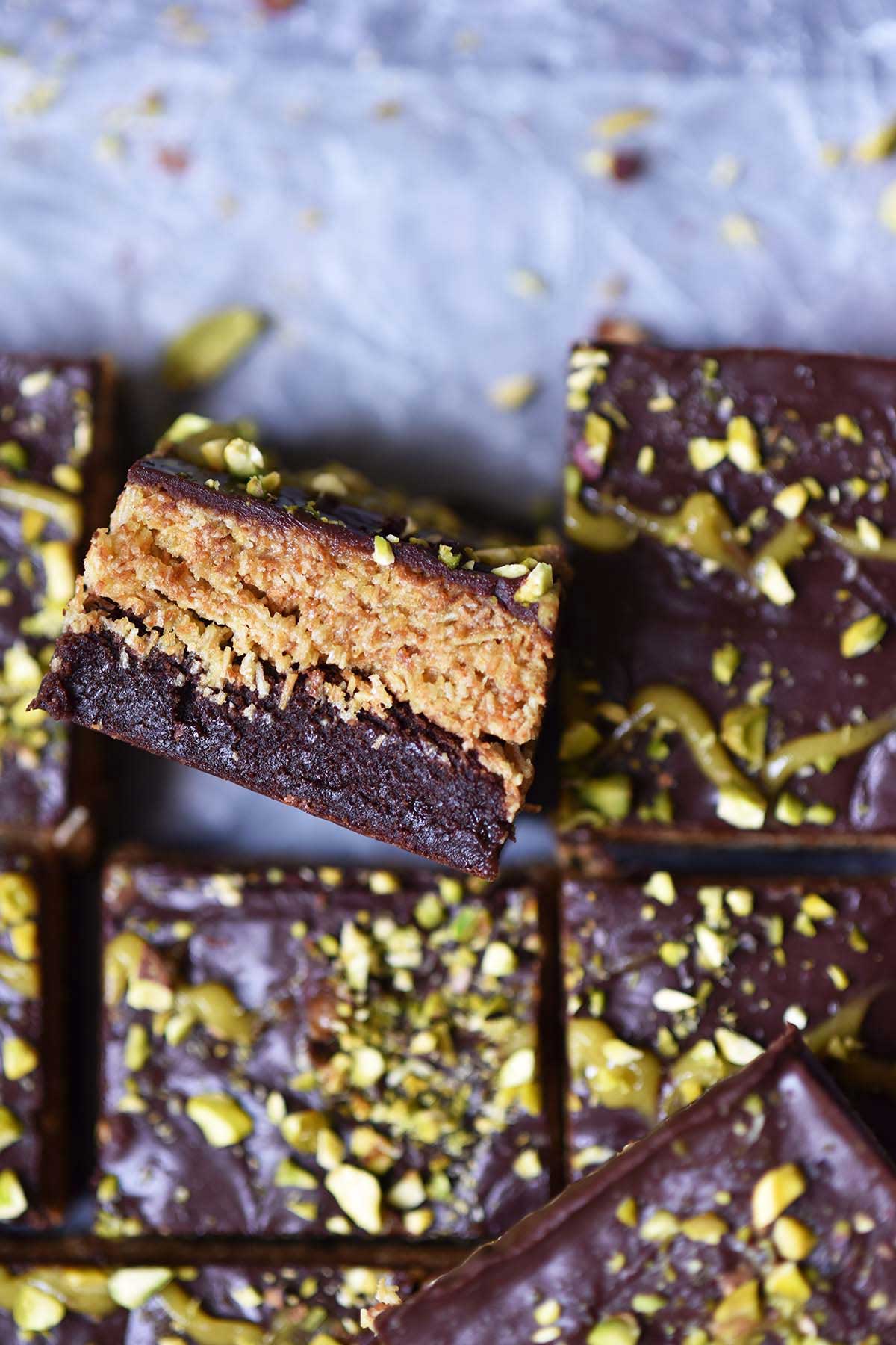 chocolate brownie topped with pistachio cream kataifi/knafeh layer and chocolate ganache