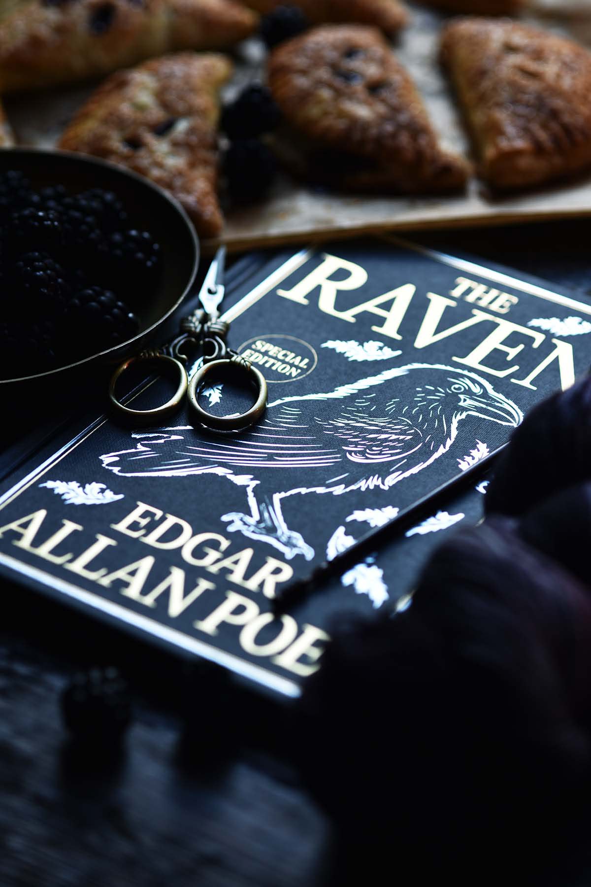 the raven book by Edgar Allan poe with blackberry tartlets in background