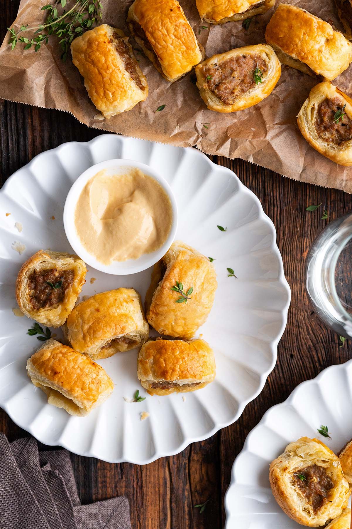 Top view of sausage roll bites on plate with small dish of dijon.